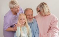 A joyful multigenerational family poses and smiles together indoors, showcasing love and togetherness.